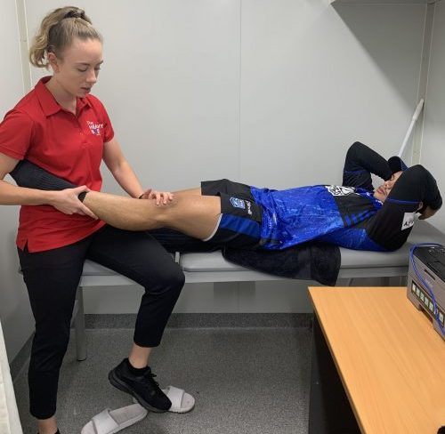 Physio treating footy player.